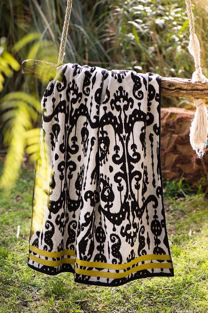 Ornately patterned towel hanging in garden