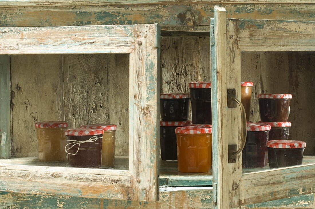 Marmeladengläser in rustikalem Holzschrank