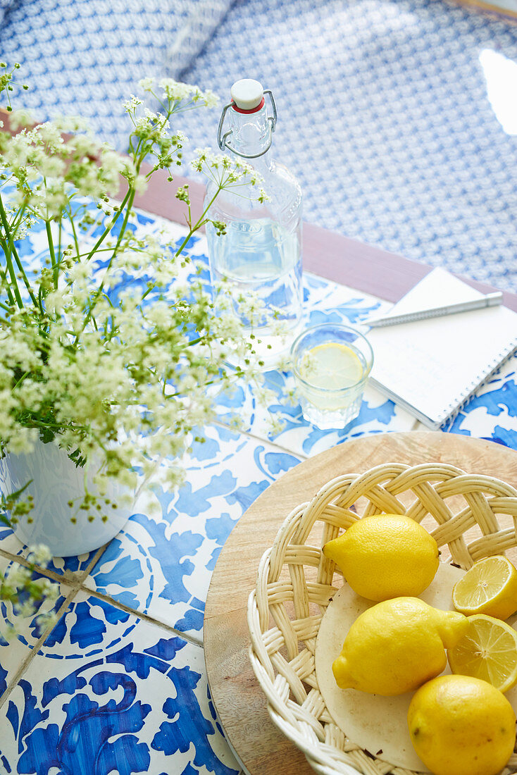 Sommerliches Stillleben mit Zitronen und Wiesenblumen