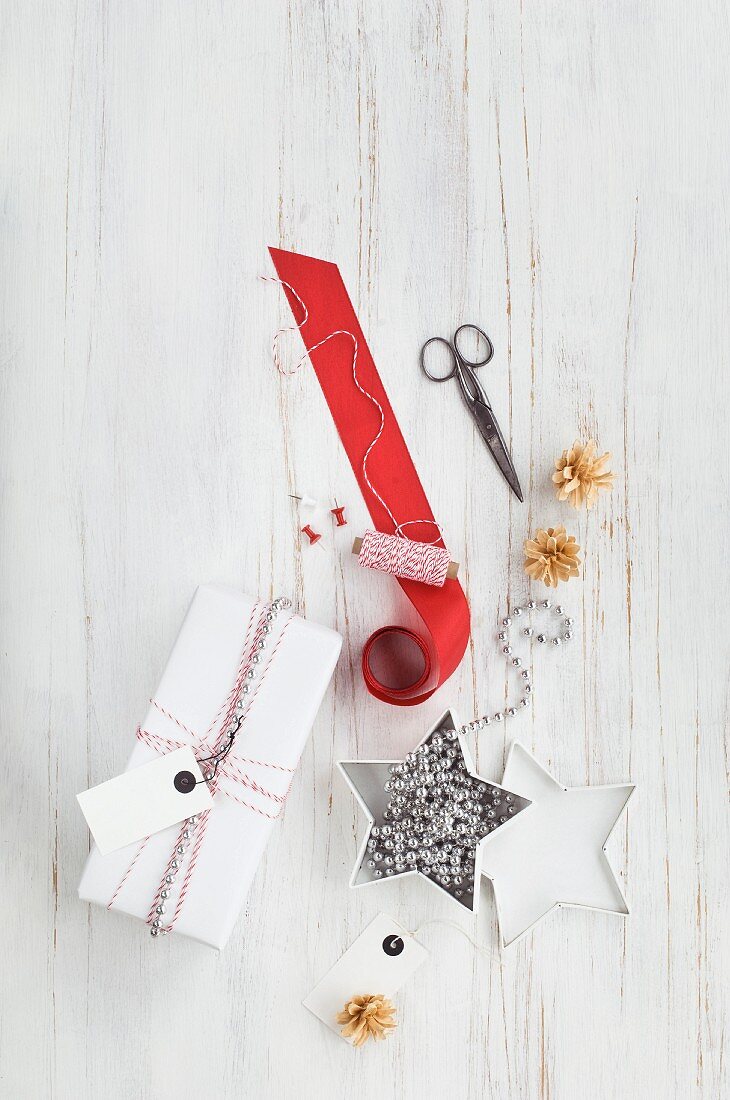 Ein rot-weiß verpacktes Geschenk und Verpackungsmaterial