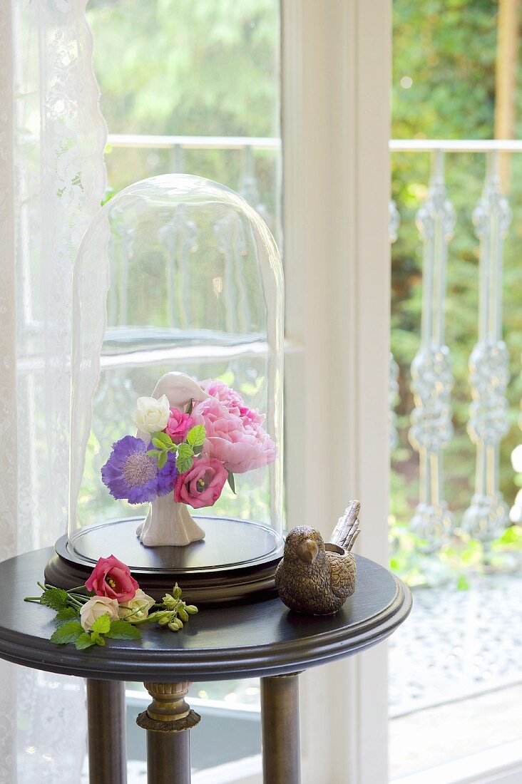 Kleiner Blumenstrauß unter einer antiken Glasglocke