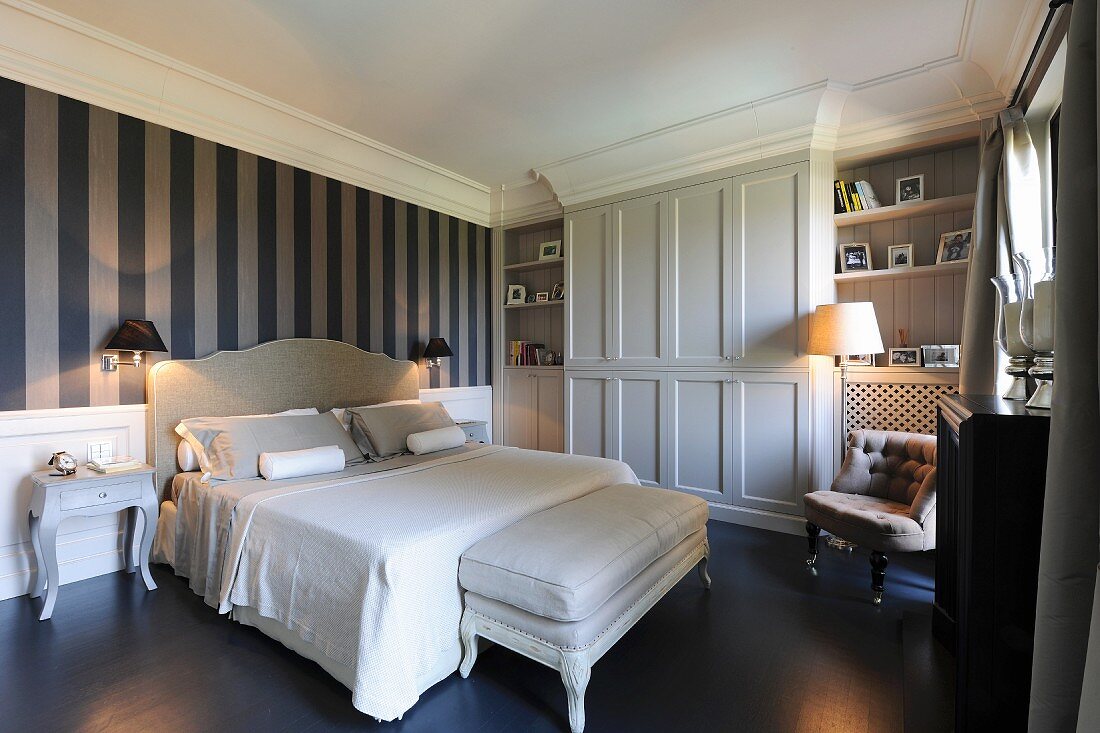 Elegantes Schlafzimmer mit Blockstreifentapete, maßgefertigeter Schrankwand