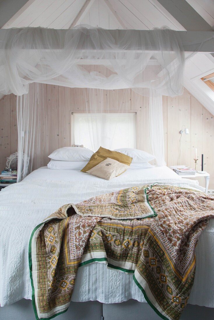 Romantisches Schlafzimmer unter dem Dach mit Bretterwand