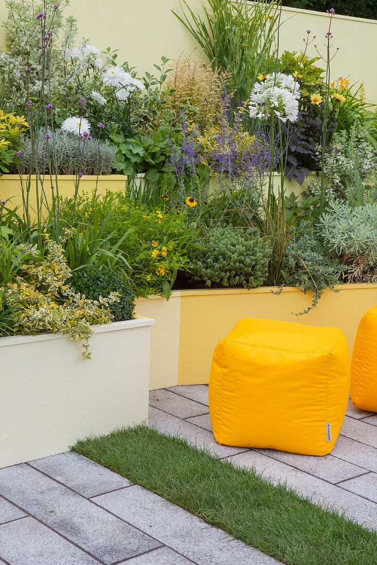 Terraced beds in shades of yellow in courtyard garden