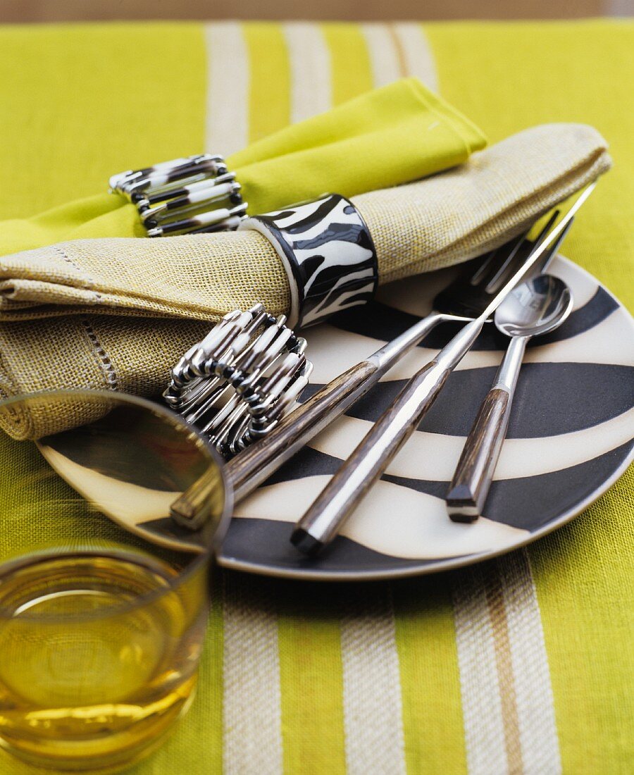 Wood-handled cutlery and linen napkin on black and white plate