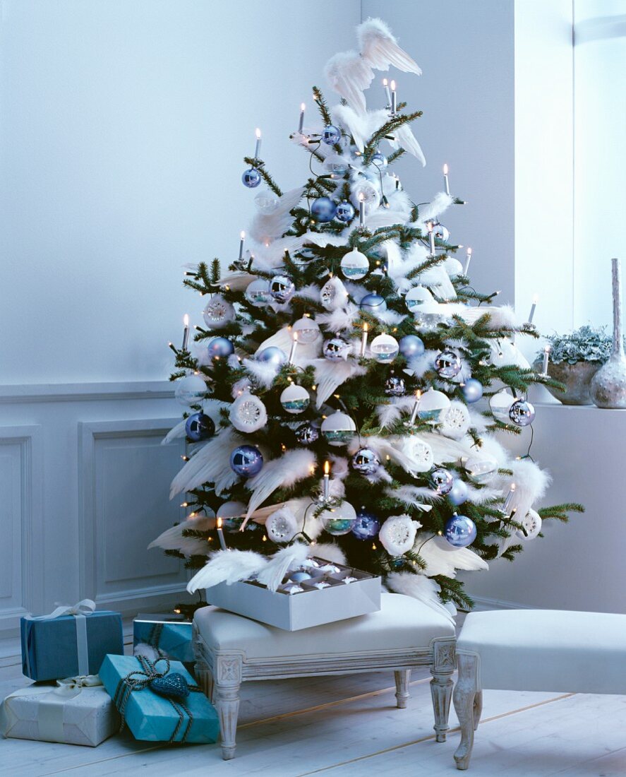 Romantisch geschmückter Weihnachtsbaum mit Dekoflügeln und pastellblauen Weihnachtskugeln in elegantem, nostalgischem Ambiente