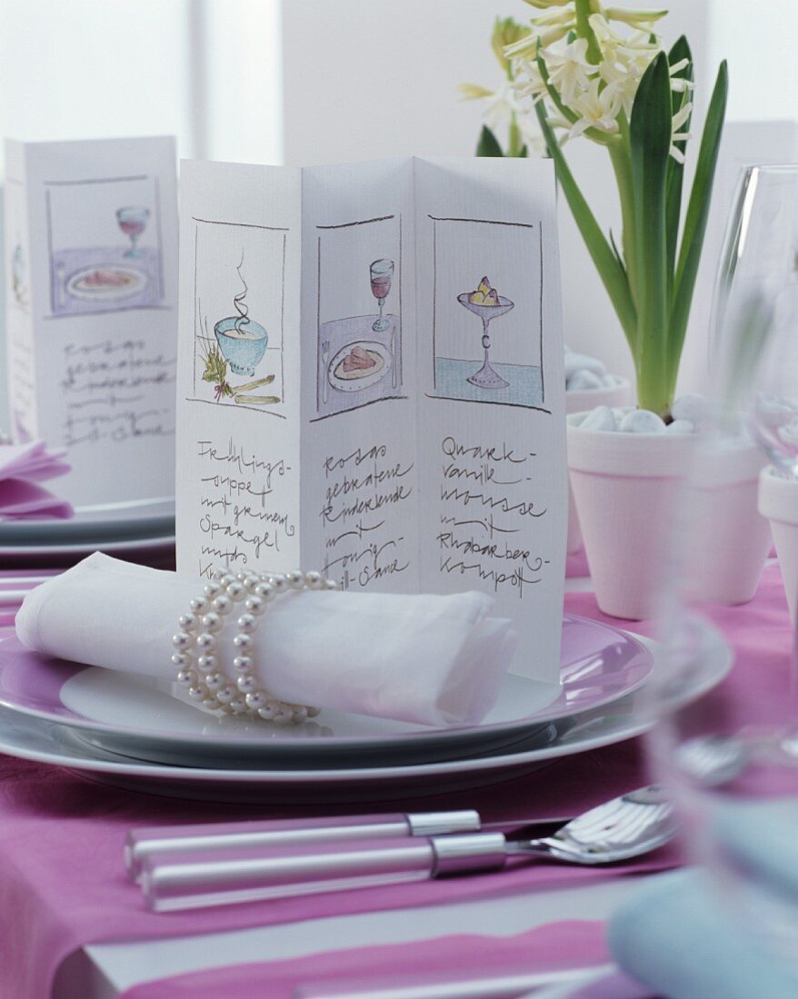 Gezeichnete Menükarte mit elegantem Serviettenring und Stoffserviette auf festlich gedecktem Tisch