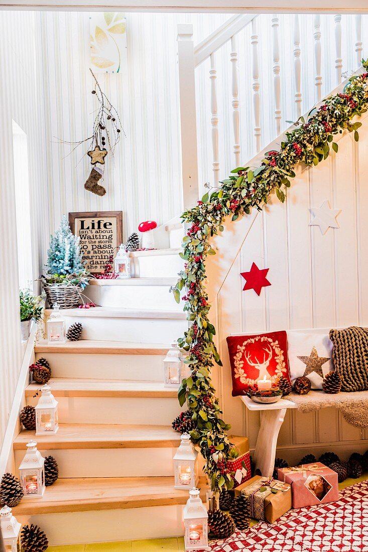 Weihnachtlich dekorierte Treppe mit Girlande, Zapfen und Laternen