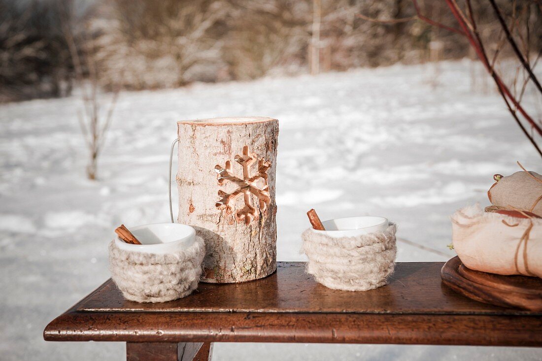 Wooden candle lantern and cups wrapped in wool for winter picnic