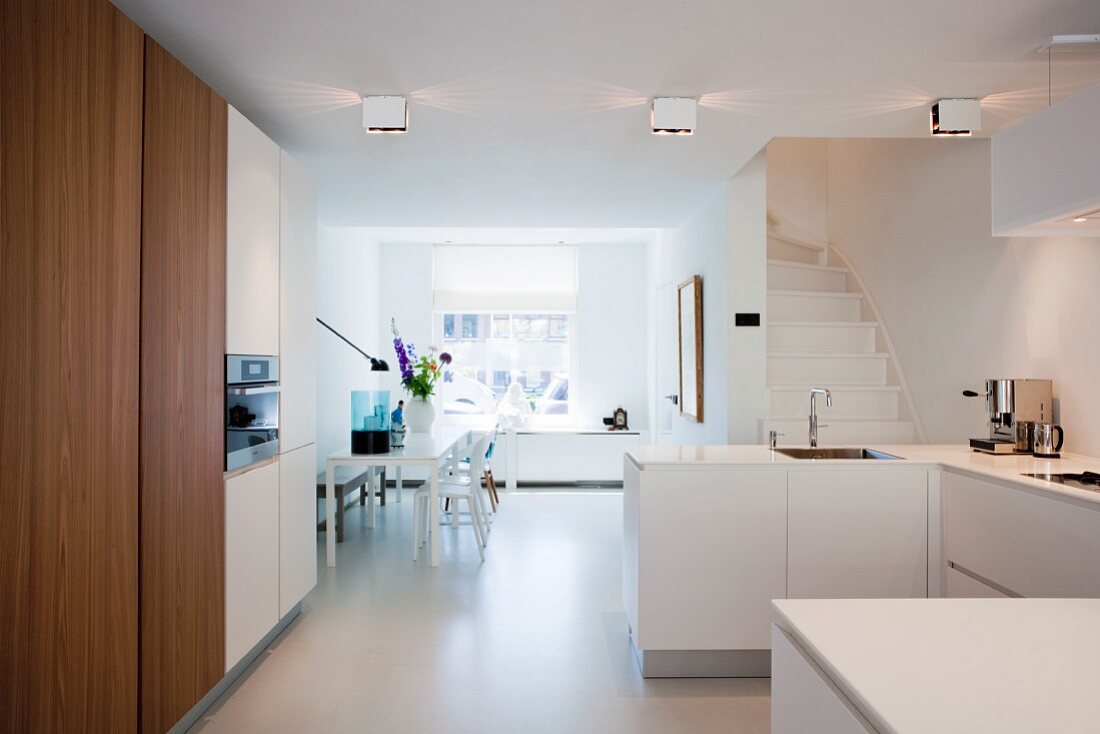 White floor and dining table in large, open-plan kitchen