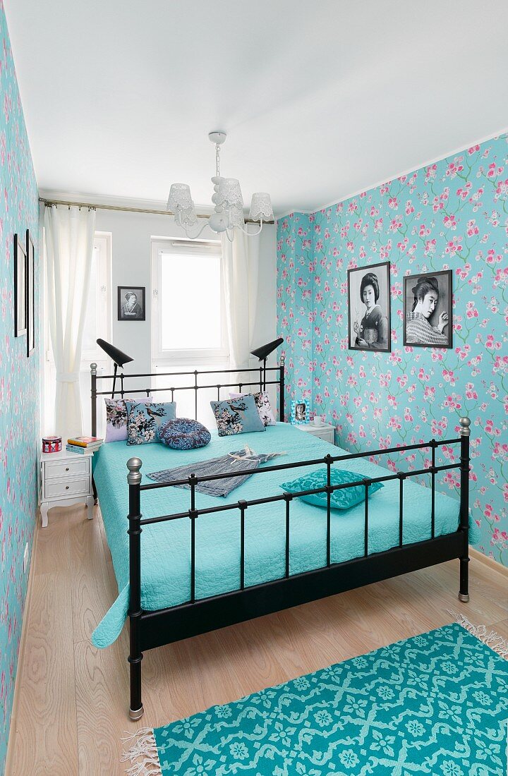 Blaues Schlafzimmer mit Metallbett und Blümchentapete