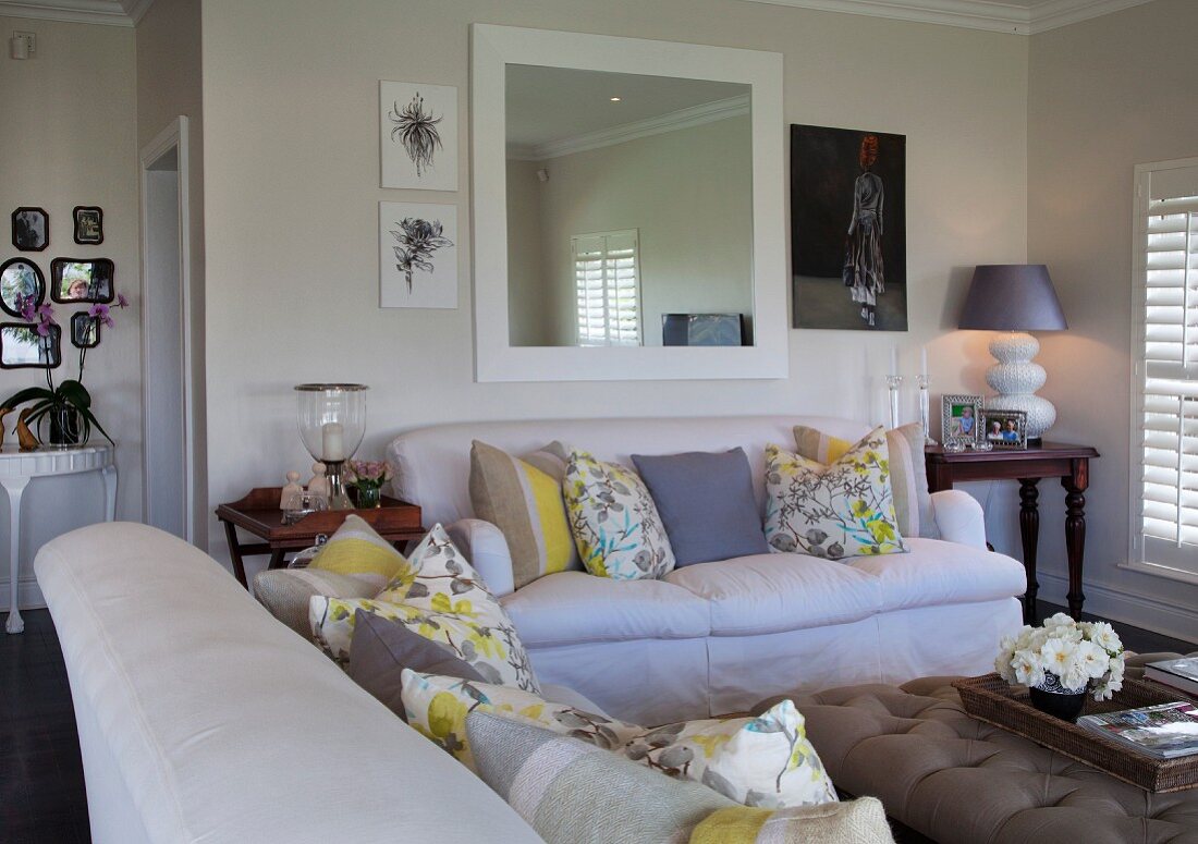 Sofagarnitur mit Kissen in hellem Wohnzimmer mit Landhaus Flair