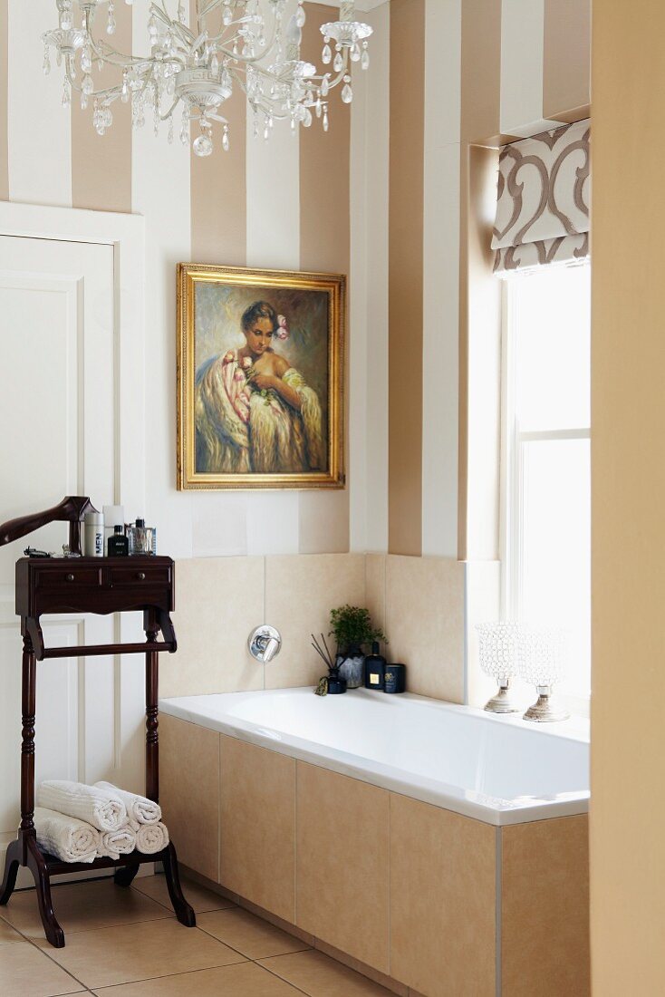 Antiker Stummer Diener aus dunklem Holz neben Badewanne am Fenster in Bad mit gestreifter Tapete