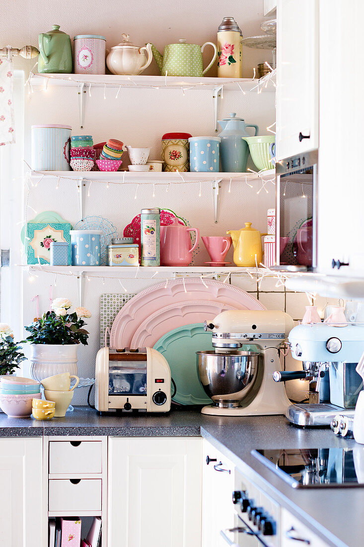 Pastellfarbenes Retro Geschirr auf Regal über Küchenzeile