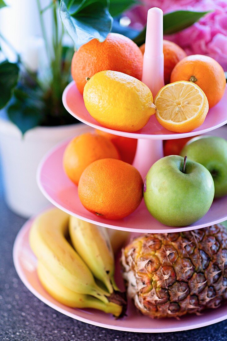 Various fruits on pink cake stand
