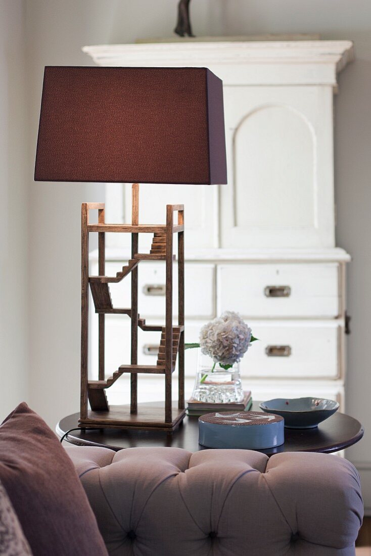 Tischleuchte mit filigranem Holzgestell und braunem Lampenschirm im Wohnzimmer