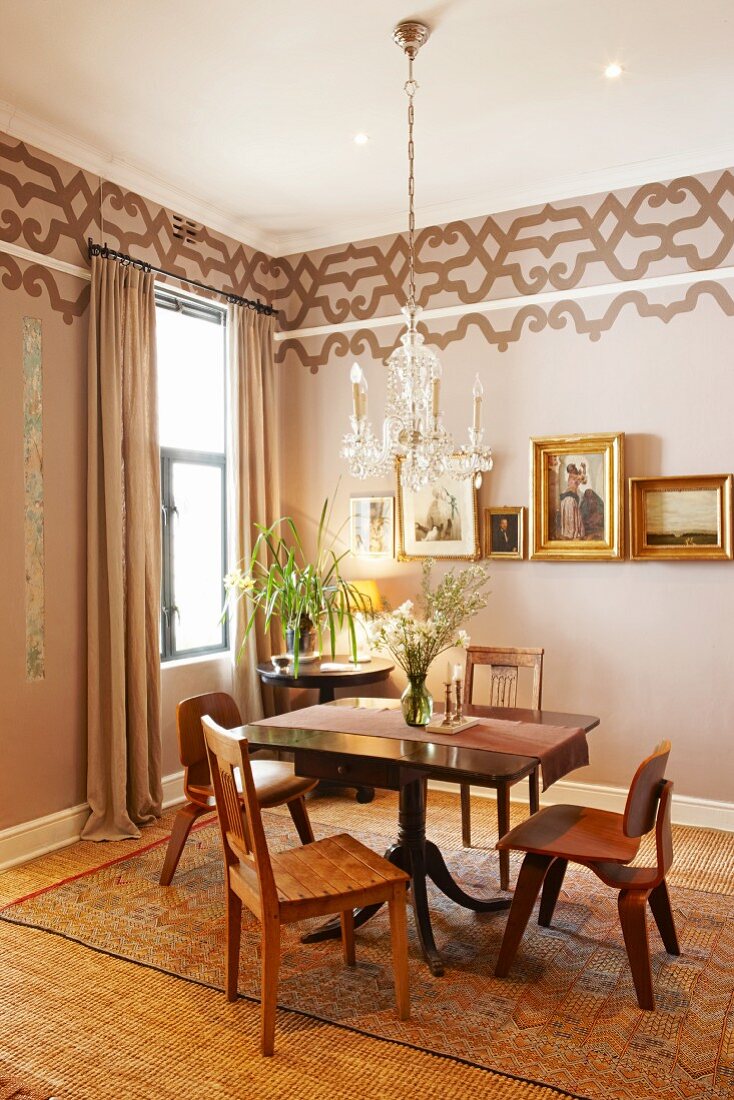 Dining area with various chairs, Biedermeier table and walls painted pale brown with stencilled friezes