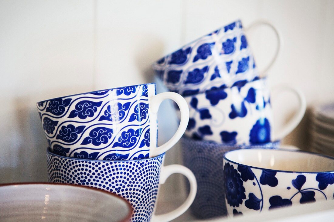 White and blue mugs painted with various patterns