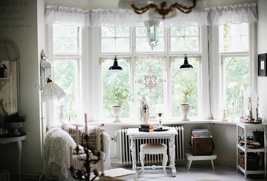 Erkerbereich mit luftiger Schabracke vor Oberlichter, weisser, traditioneller Beistelltisch mit passendem Schemel vor Fenster