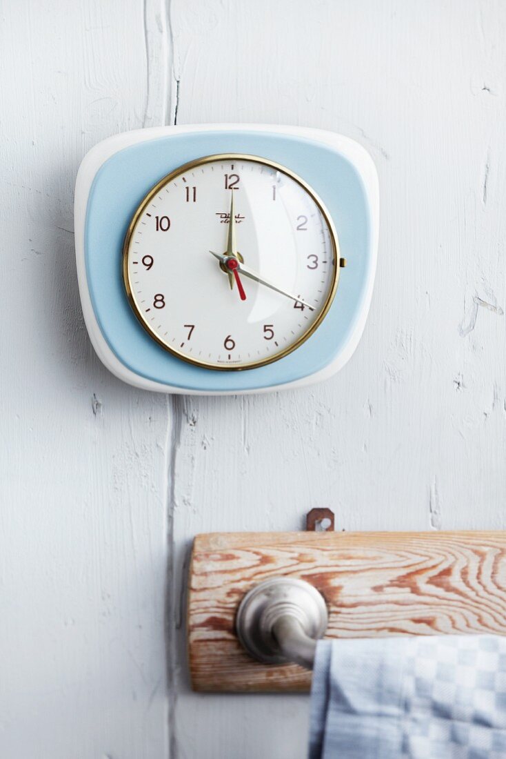Wall clock in kitchen above towel rack
