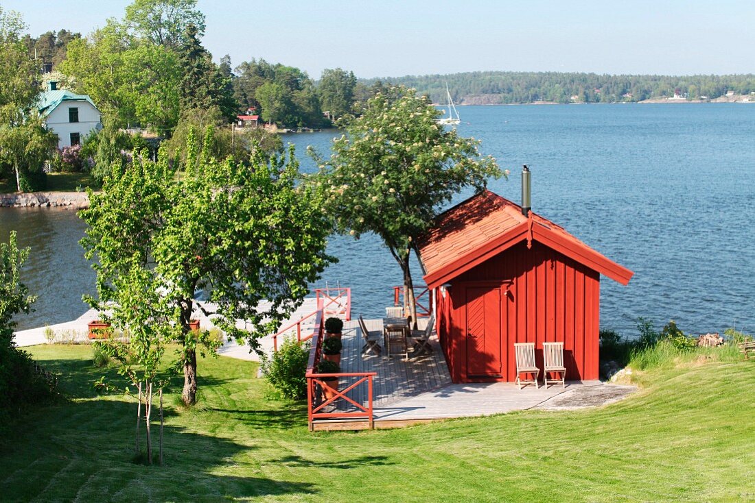 Kleines, rotes Holzhaus an der schwedischen Schärenküste