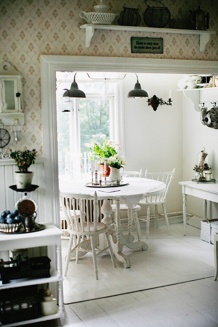 View through wide, open doorway into white dining area with rustic ambiance