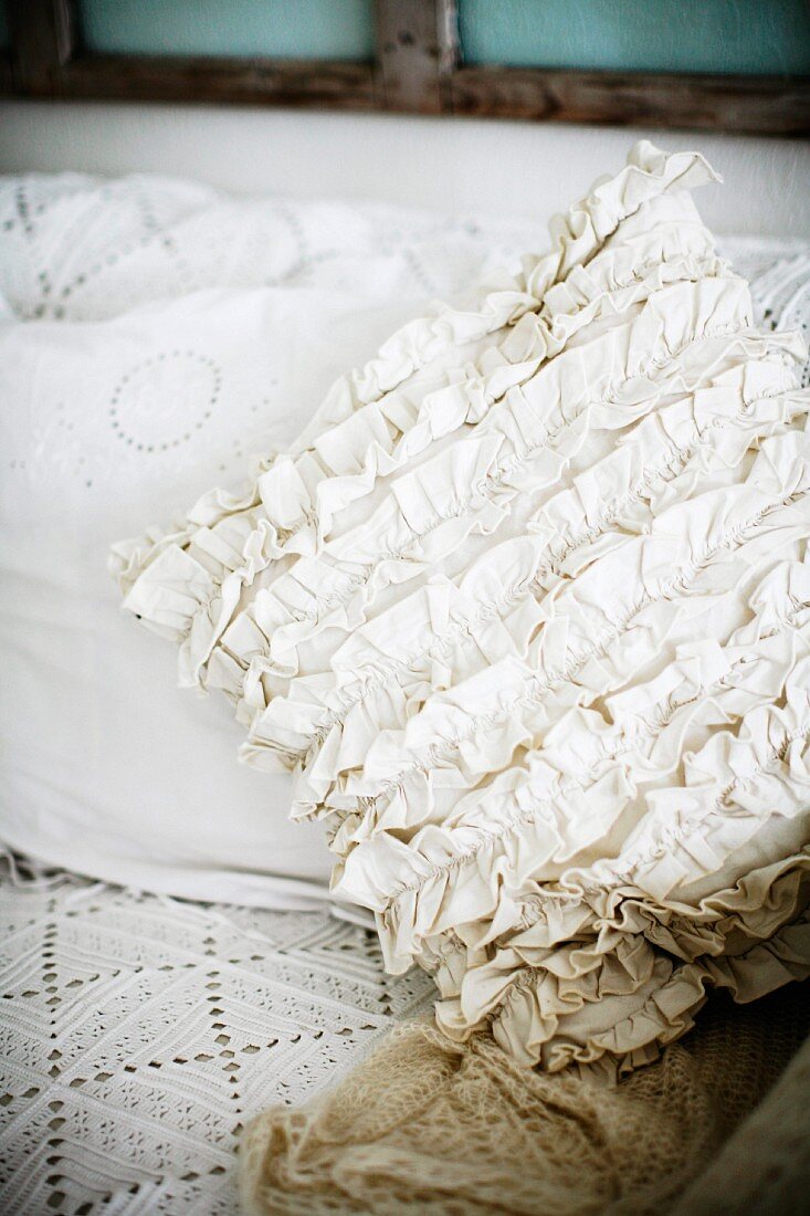 Cushion with white ruffled cover