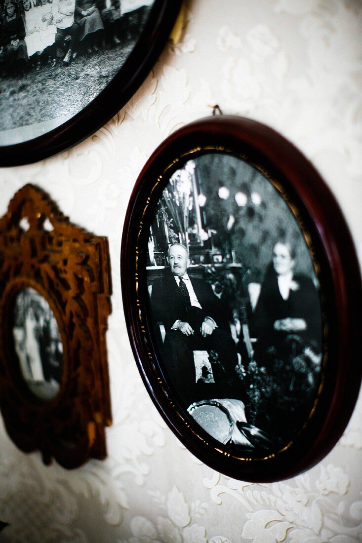 Black and white photos in dark wooden frame on wall