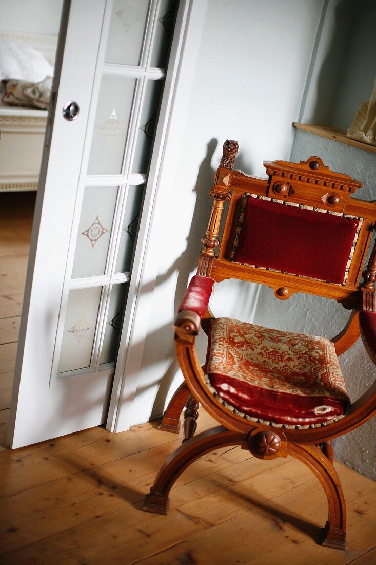 Regency-style, antique chair in corner next to lattice, sliding door