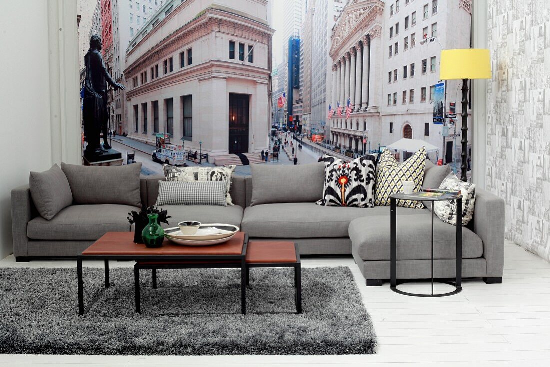 Mehrteiliges Couchtisch-Set und graues Sofa vor New York Tapete