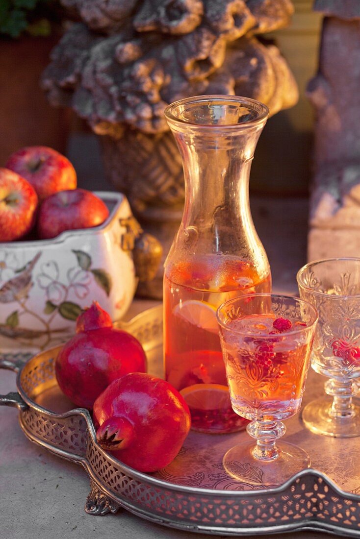 Refreshing drinks and pomegranates on vintage silver tray