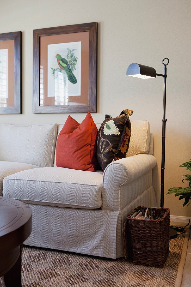 Floor lamp by cropped couch in the living room; California; USA