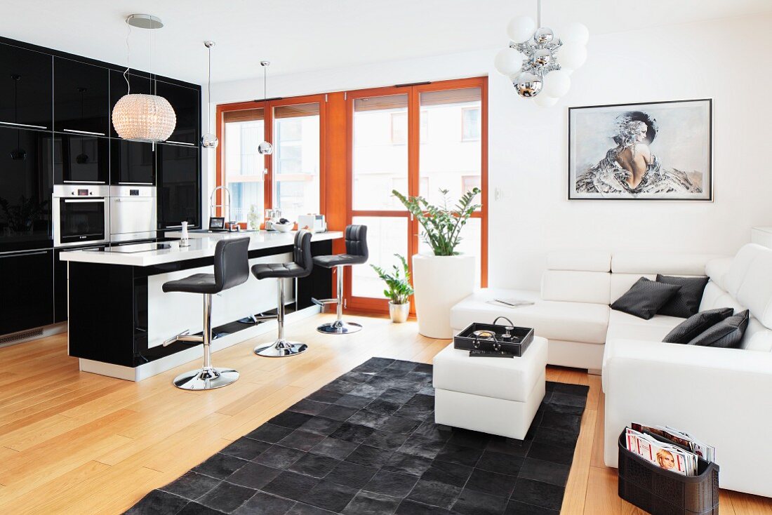 An open plan living area with a view towards a breakfast bar and a sitting area in black and white
