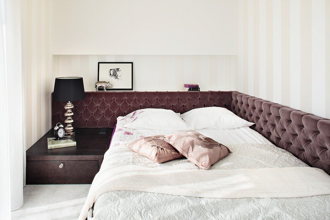 Mit braunen Samtpolstern und Nachtkasten eingerahmtes, französisches Bett in elegantem Schlafraum