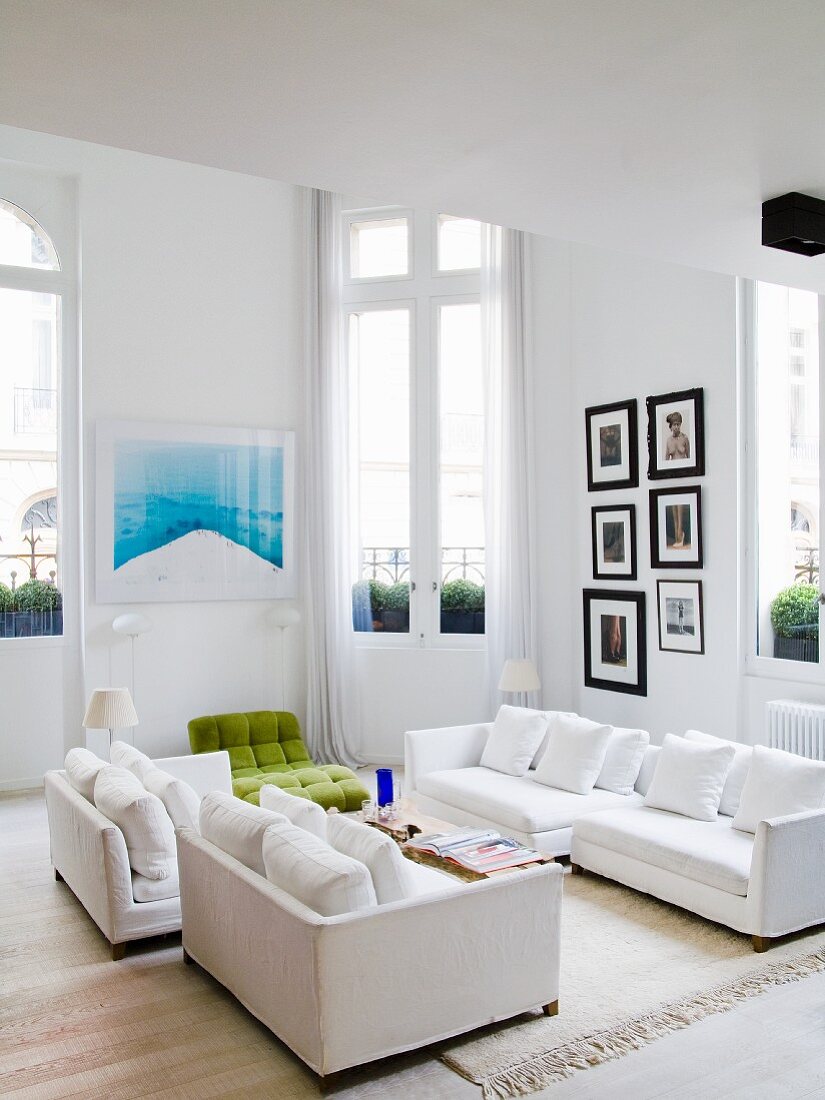 weiße Sofagarnitur im Wohnzimmer mit Balkontüren in einer Altbauwohnung