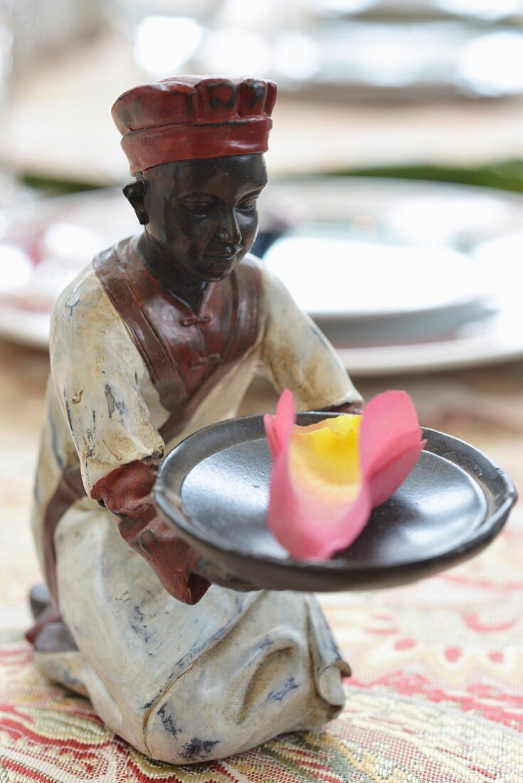 Kleine Keramikfigur mit duftenden Blütenblättern