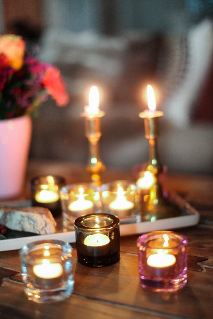 Romantic candlelight atmosphere with candlesticks and several tealight holders on rustic wooden table