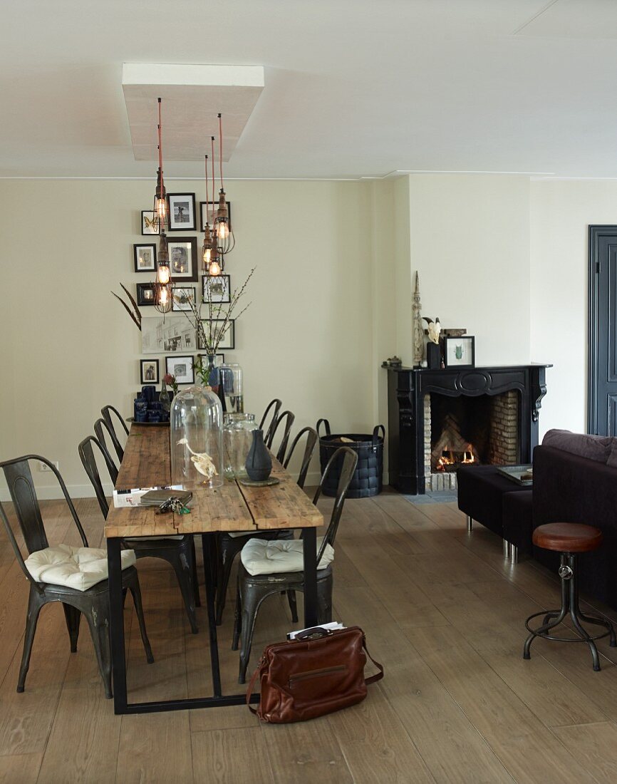 Tisch mit Holzbohlen-Platte und Klassiker Stühle aus Metall in minimalistischem Ambiente