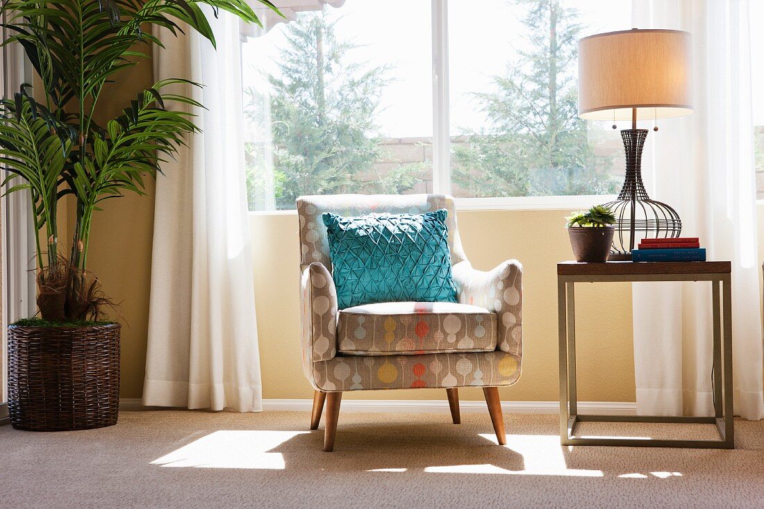 Blue throw pillow on armchair by window