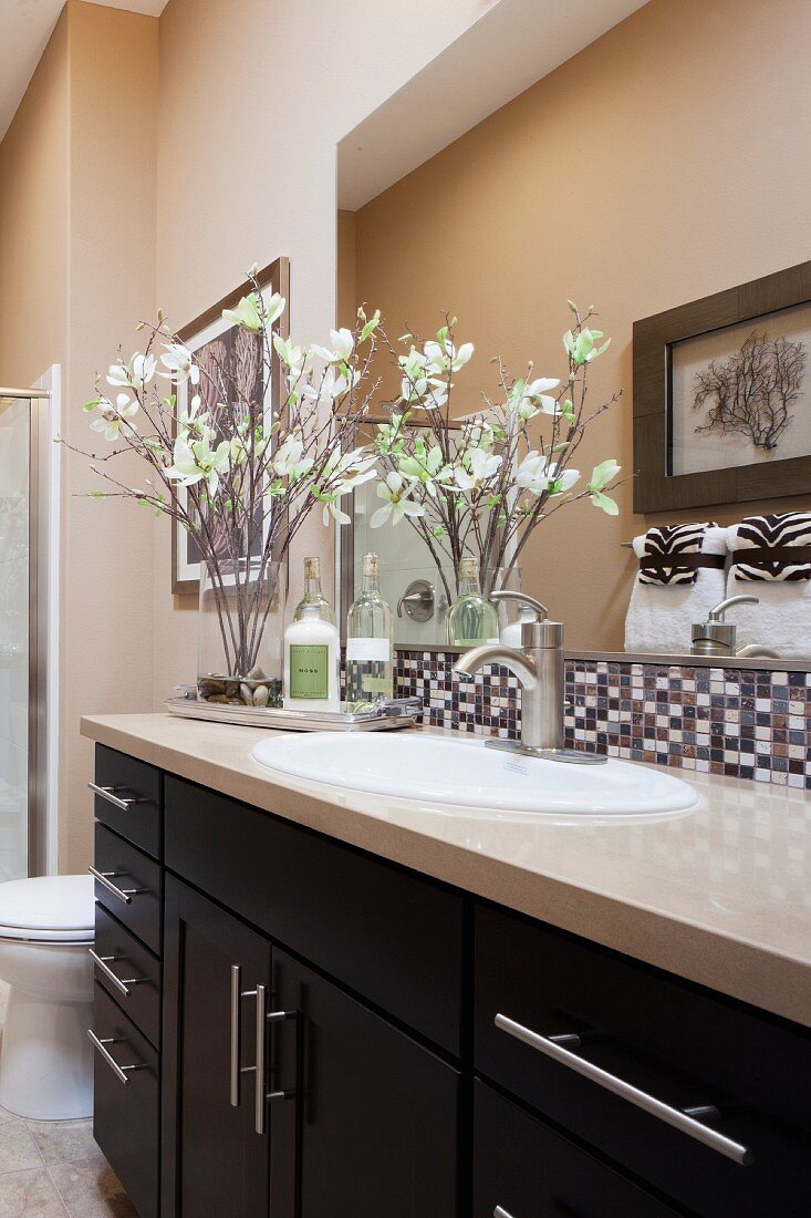 Moderner Waschtisch mit Spiegel, Mosaikfliesen und dekorativen Blumen