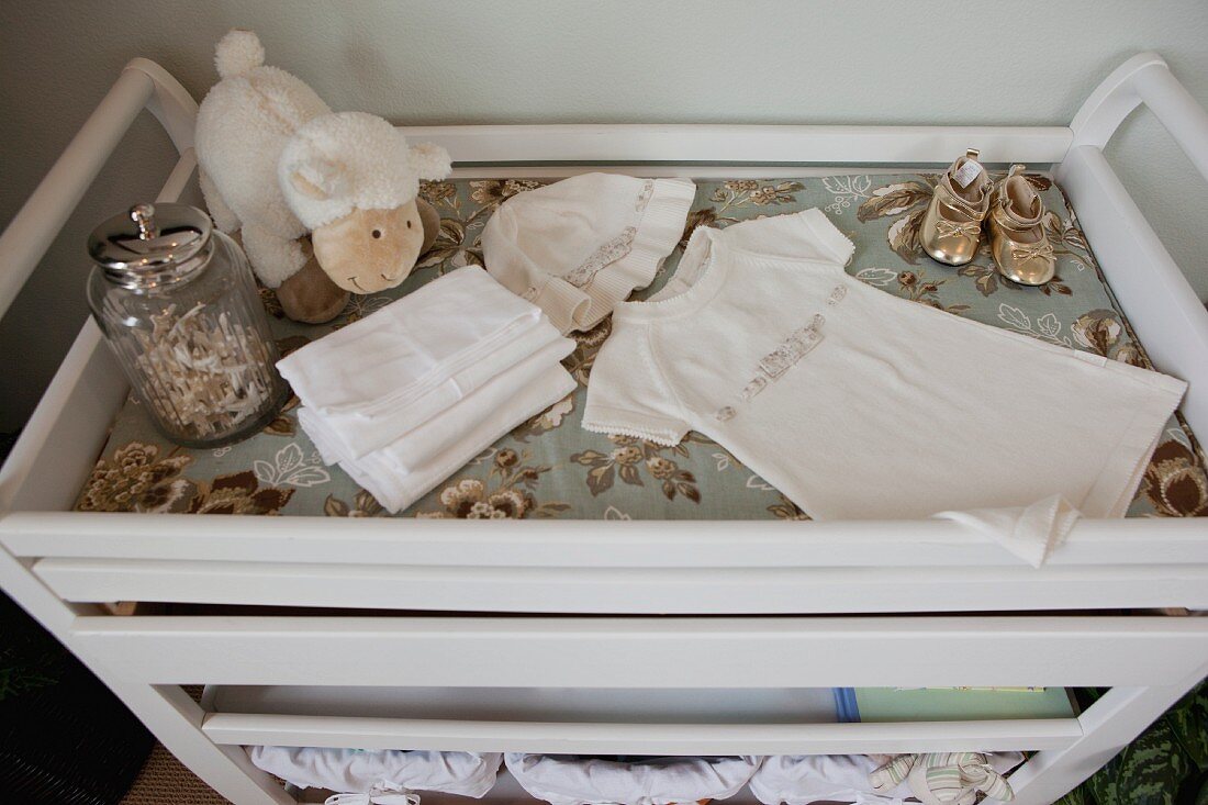 Detail of baby clothes on white trolley