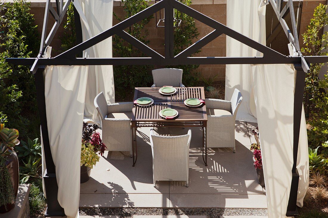 View down onto dining area with curtains in garden