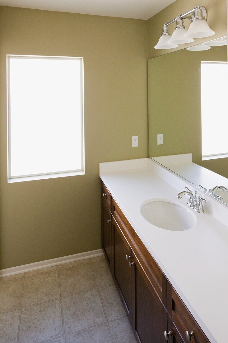 Mirror with wall lamps over washbasin in the bathroom