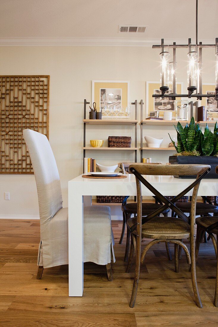 Chairs at dining table with shelves in the background; San Marcos; California; USA
