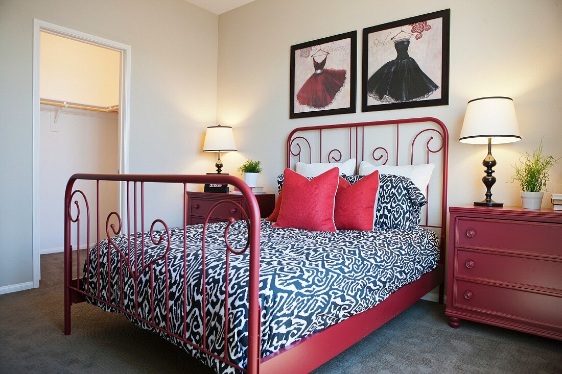 Schmiedeeisernes rotes Bett mit roten Kommoden als Nachttische
