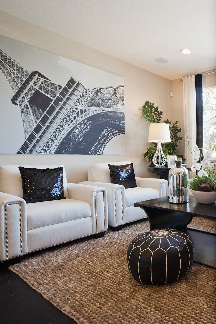 Wohnzimmer mit weissen Ledersesseln & Wandbild mit Fotomotiv vom Eiffelturm