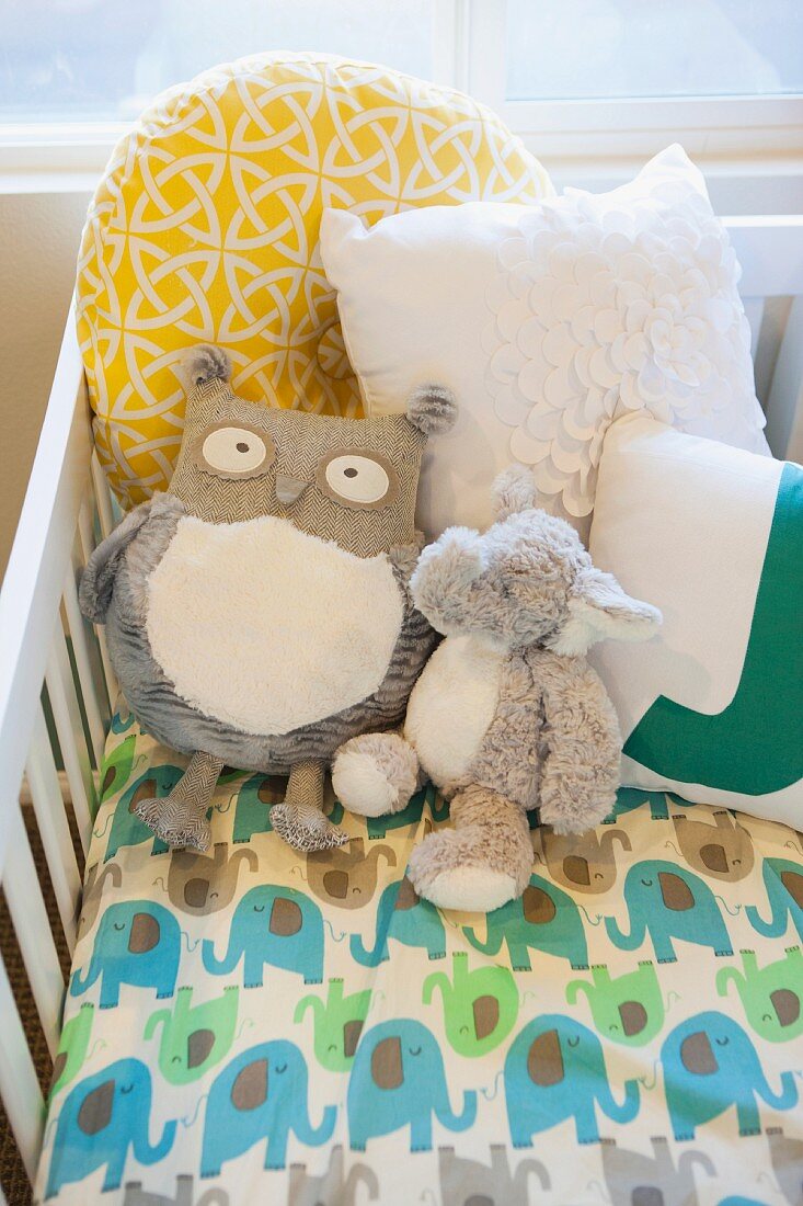 Soft toys in crib in nursery