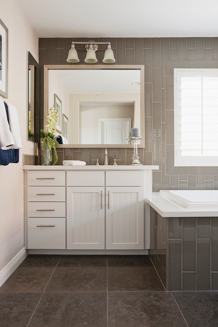 Grau gefliestes Badezimmer mit weißem Waschtisch
