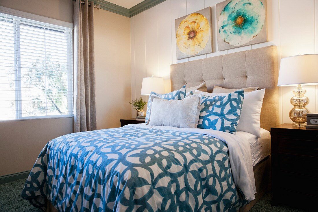 Doppelbett mit Polsterkopfteil sowie Nachttische & Tischleuchten in Schlafzimmer mit holzverkleideten Wänden