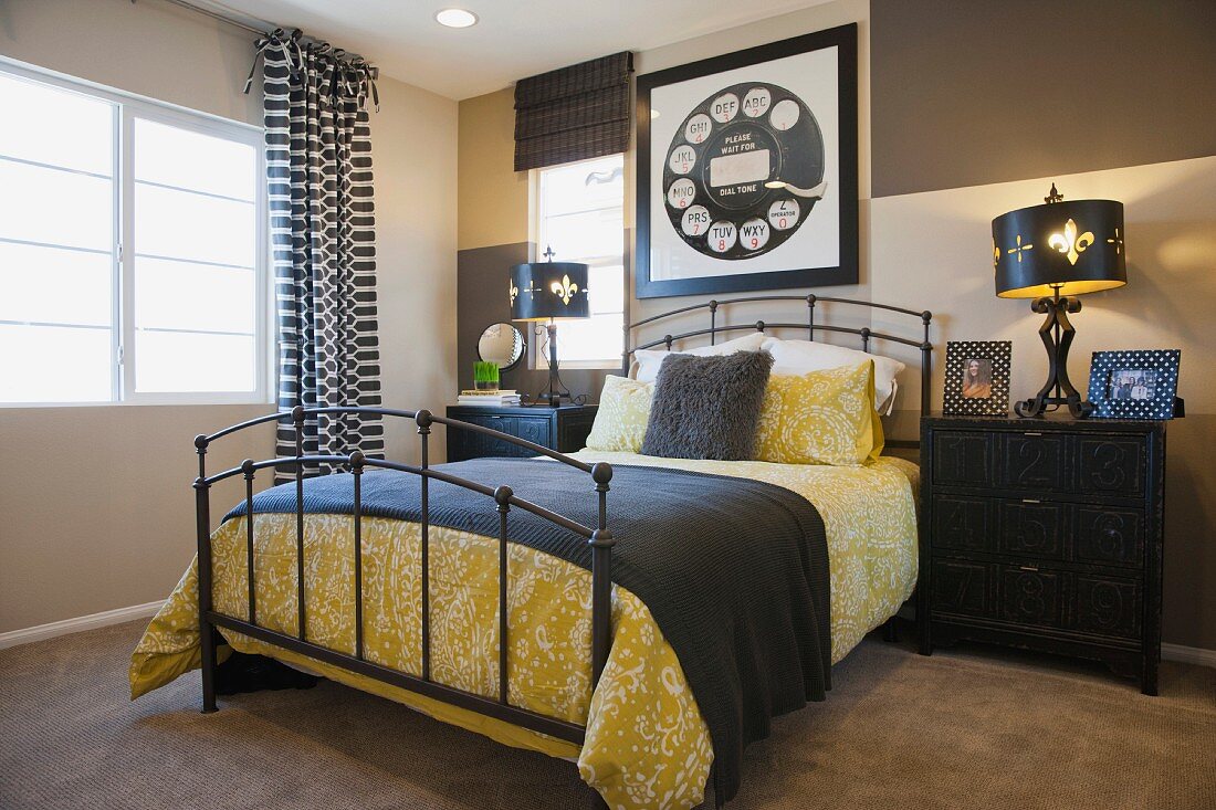 Zeitgenössisches Schlafzimmer in Grau mit gelben Farbakzenten, Metallbett, Kommoden als Nachttische & Wandbild mit Telefonwählscheibe als Motiv